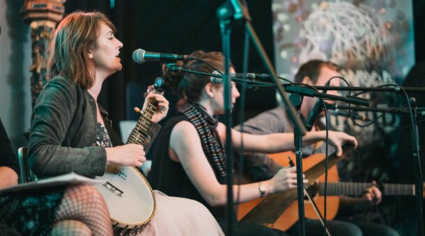 picture of 3 musicians playing a banjo, a violin and a guitar
