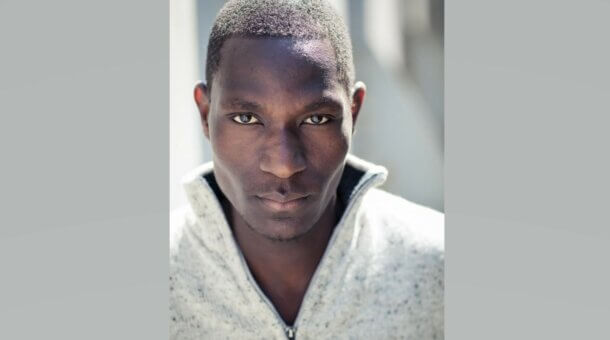 photo of the actor John Rwothomach looking directly into camera
